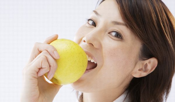 リンゴを食べる女性の画像